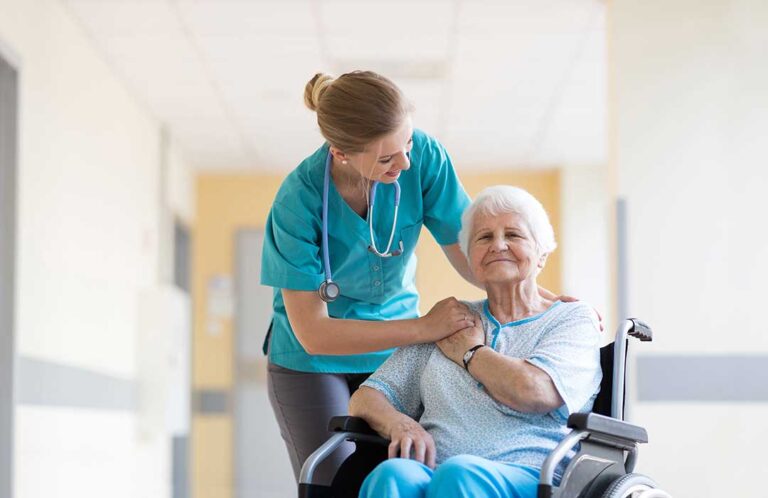 An elderly person and a caregiver sharing an activity together at a table in a cozy assisted living common room.
