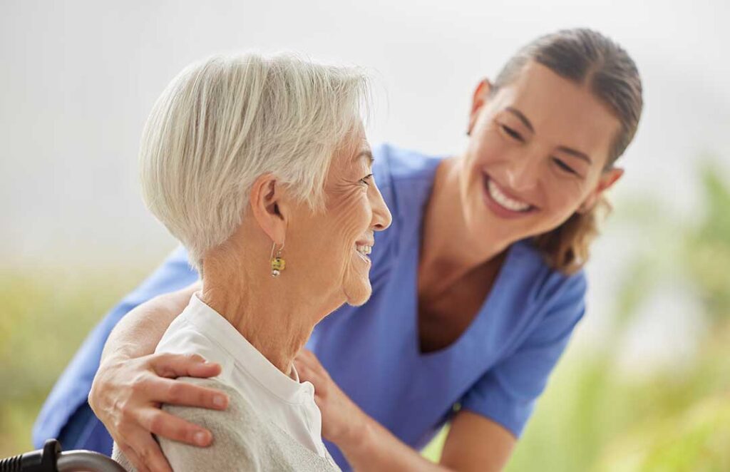 Older adult using a walker while practicing a supervised hallway walk with a caregiver.